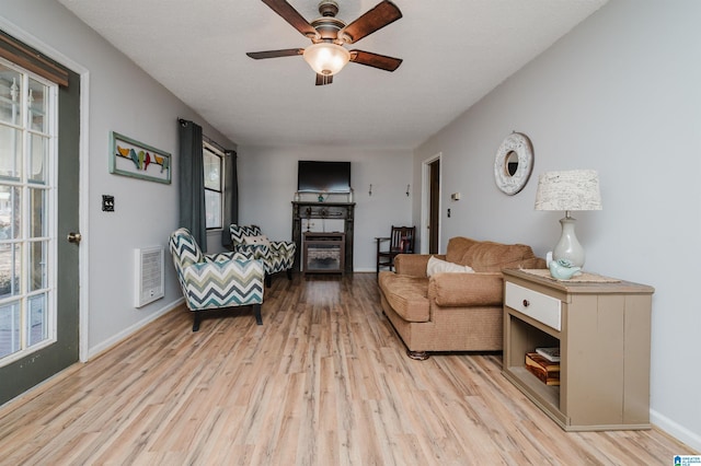 living room with light hardwood / wood-style floors and ceiling fan