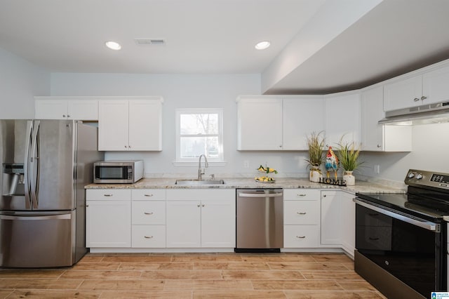 kitchen featuring sink, white cabinets, light stone countertops, and appliances with stainless steel finishes