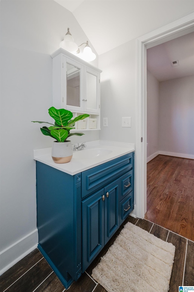 bathroom with lofted ceiling and vanity