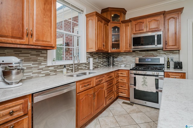 kitchen with tasteful backsplash, sink, ornamental molding, light tile patterned floors, and stainless steel appliances