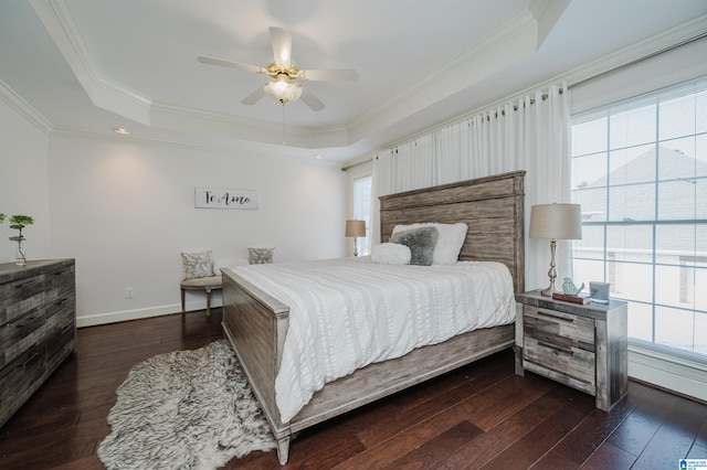 bedroom featuring dark wood-type flooring, ornamental molding, and a raised ceiling