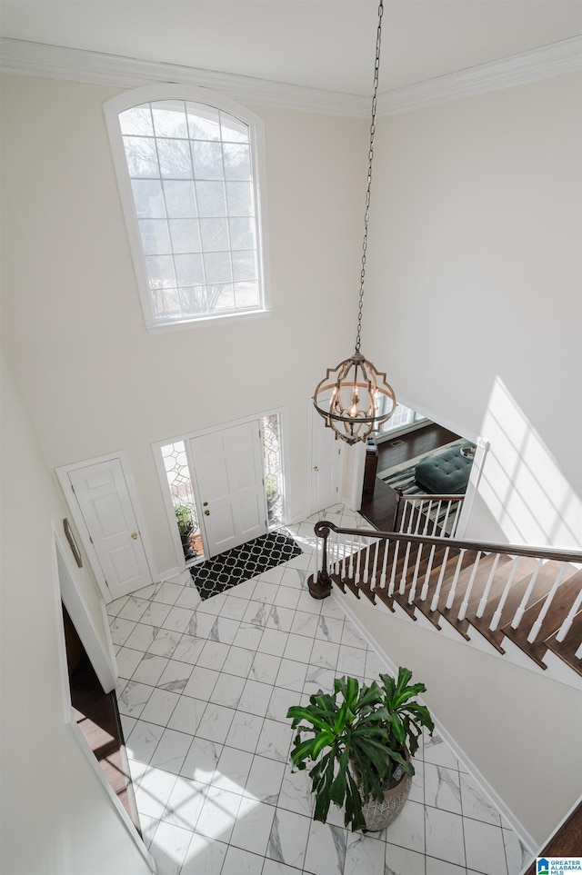 entryway with a towering ceiling and ornamental molding