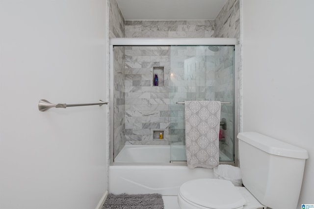 bathroom with bath / shower combo with glass door and toilet