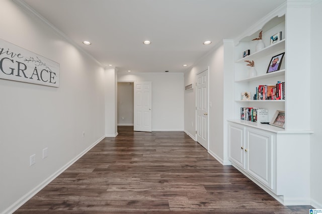 corridor with crown molding, dark hardwood / wood-style flooring, and built in shelves