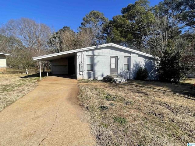 exterior space featuring an attached carport, concrete driveway, and brick siding