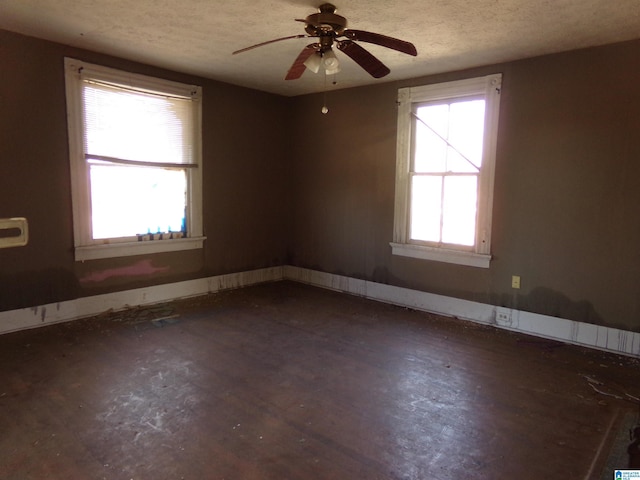 spare room featuring a healthy amount of sunlight, a textured ceiling, and ceiling fan