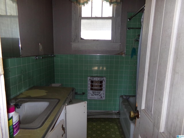 bathroom with vanity and tile walls