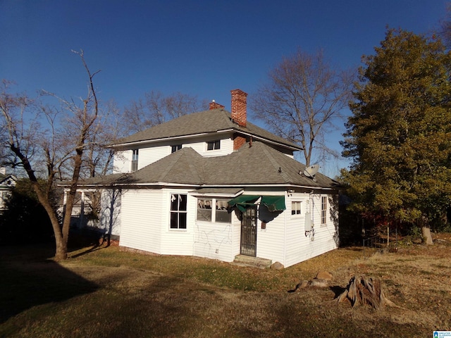 rear view of house featuring a lawn