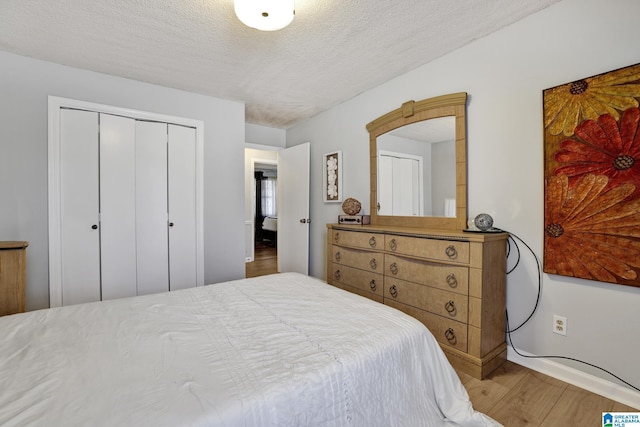 bedroom featuring a textured ceiling, a closet, and hardwood / wood-style floors