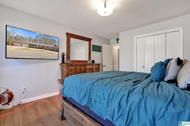 bedroom featuring hardwood / wood-style flooring, a textured ceiling, and a closet