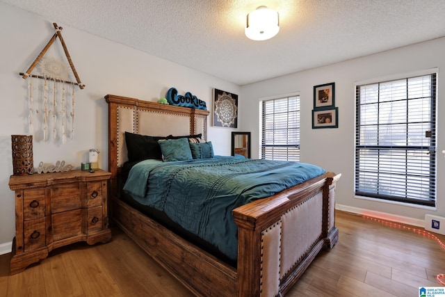 bedroom with hardwood / wood-style flooring and a textured ceiling