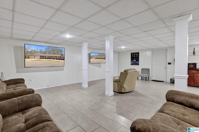 tiled living room featuring decorative columns and a paneled ceiling