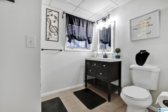 bathroom featuring tile patterned floors, toilet, a paneled ceiling, and vanity