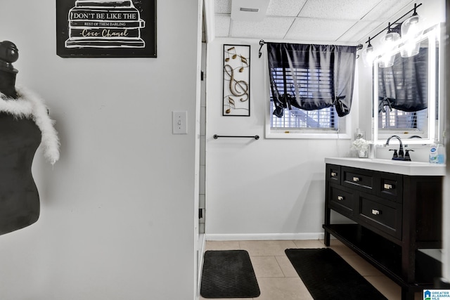 bathroom featuring vanity, tile patterned floors, and a drop ceiling