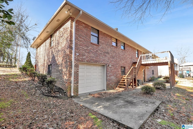 rear view of property with a garage and a wooden deck