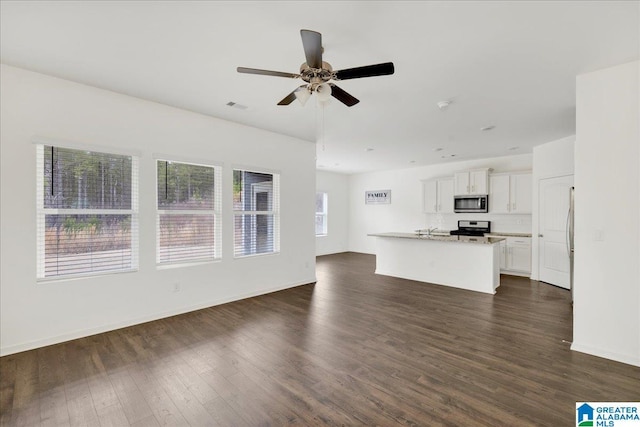 unfurnished living room with dark hardwood / wood-style floors and ceiling fan