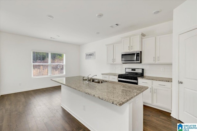 kitchen featuring stainless steel appliances, an island with sink, sink, and white cabinetry