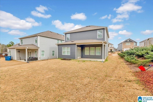 back of house with a patio area and a lawn