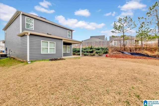 back of house featuring a yard and central AC