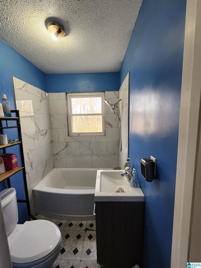 full bathroom with vanity, tiled shower / bath, a textured ceiling, and toilet