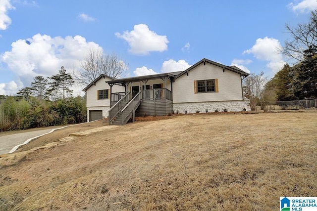 view of front of property with covered porch, a garage, and a front lawn