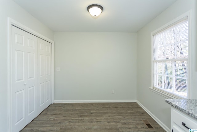 unfurnished bedroom featuring a closet and dark hardwood / wood-style flooring