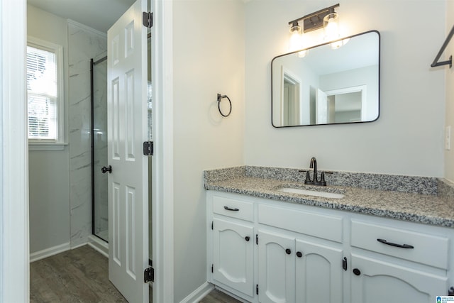 bathroom with hardwood / wood-style flooring, a shower with shower door, and vanity