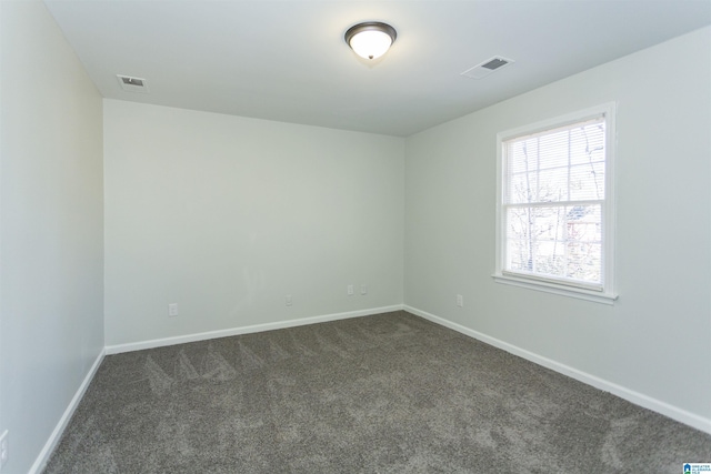 unfurnished room featuring dark carpet