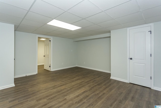 basement with a drop ceiling and dark hardwood / wood-style floors