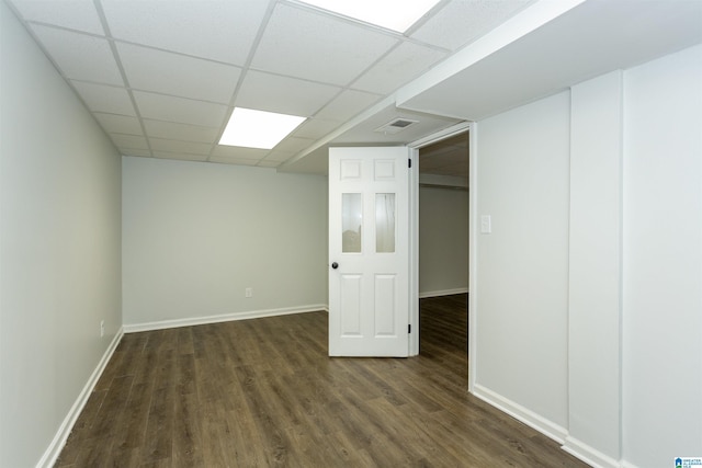 basement featuring a drop ceiling and dark hardwood / wood-style flooring