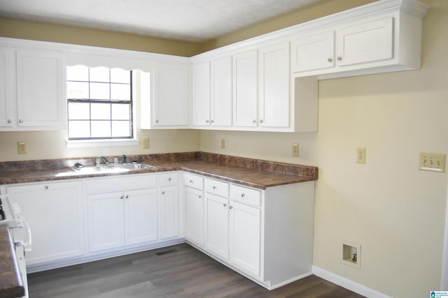 kitchen featuring a textured ceiling, white cabinetry, sink, dark hardwood / wood-style floors, and stove