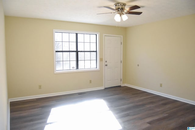 spare room with dark hardwood / wood-style floors and ceiling fan