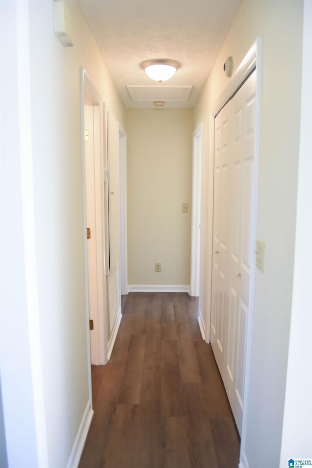 hallway featuring dark wood-type flooring and a textured ceiling