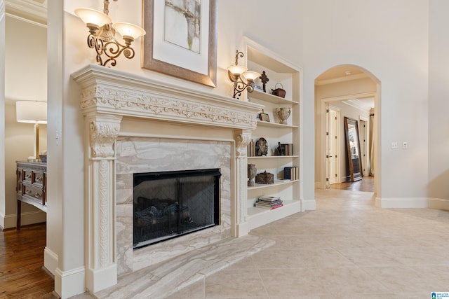 interior space with a premium fireplace, built in shelves, and ornamental molding