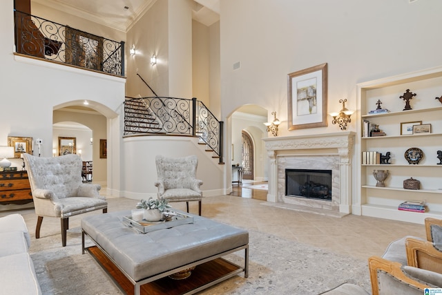 living room featuring a high end fireplace, built in features, and a towering ceiling