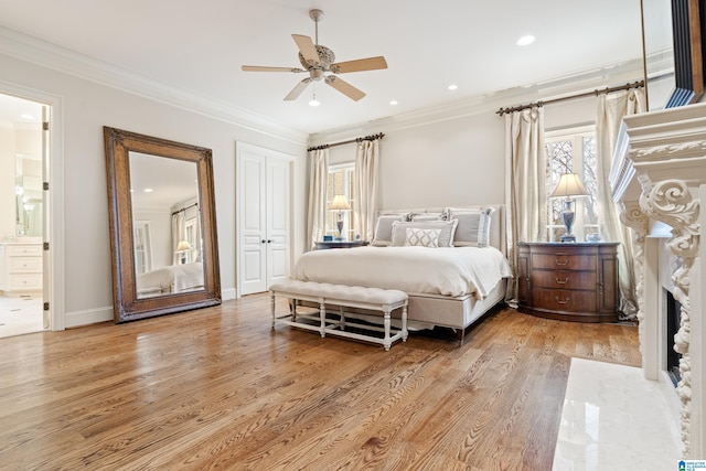 bedroom with light wood-type flooring, ceiling fan, ornamental molding, and ensuite bath