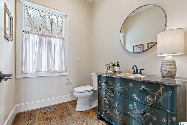 bathroom featuring wood-type flooring, toilet, and vanity