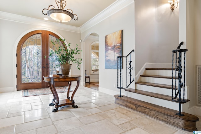 foyer with ornamental molding and french doors