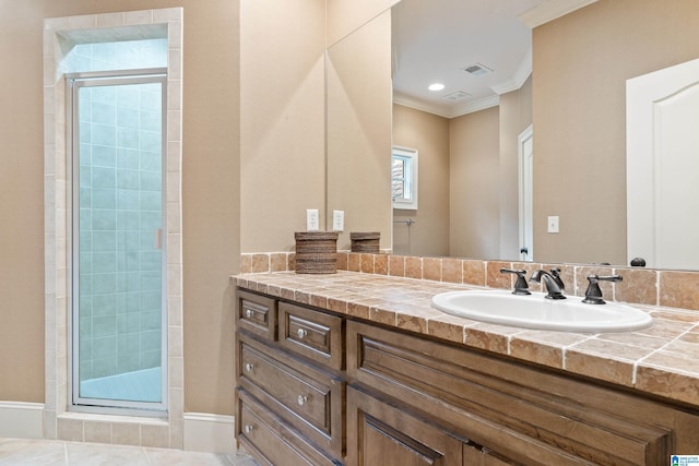 bathroom with tile patterned floors, walk in shower, crown molding, and vanity