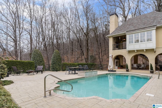 view of pool with ceiling fan and a patio