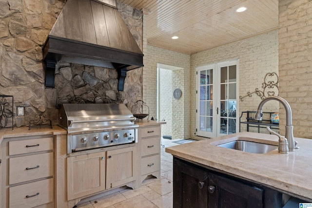 kitchen featuring wooden ceiling, premium range hood, light brown cabinetry, and sink