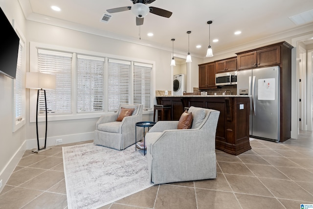 tiled living room with crown molding, washer / clothes dryer, and ceiling fan