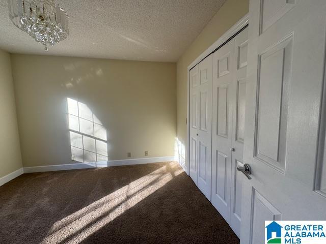 unfurnished bedroom featuring a closet, carpet, and a textured ceiling