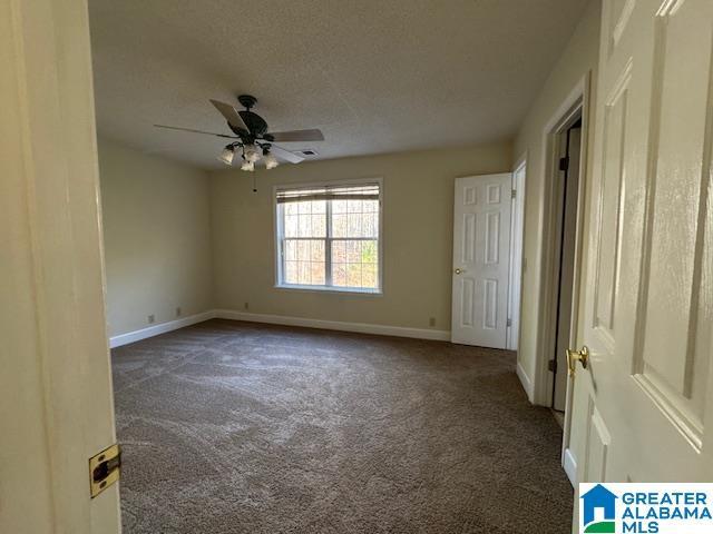 carpeted empty room featuring a textured ceiling and ceiling fan