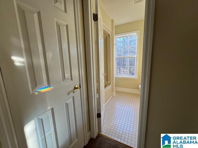 hallway with tile patterned floors