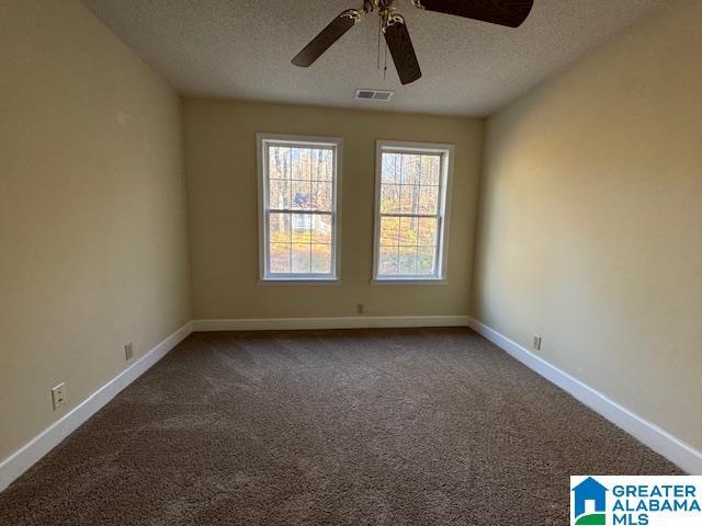 empty room featuring ceiling fan, a textured ceiling, and carpet flooring