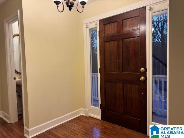 foyer entrance featuring a notable chandelier and dark wood-type flooring