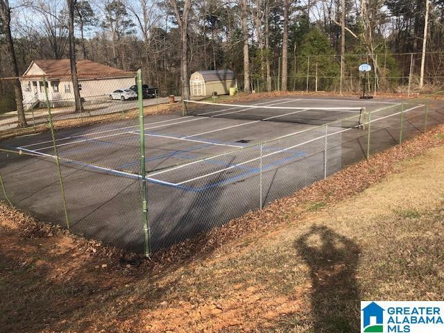 view of tennis court with a storage shed