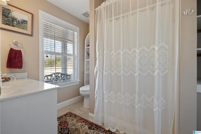 bathroom featuring vanity, toilet, plenty of natural light, and tile patterned flooring