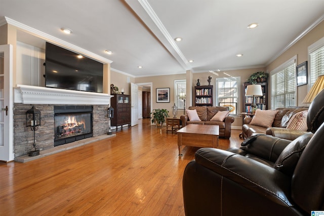 living room with a fireplace, light wood-type flooring, and crown molding